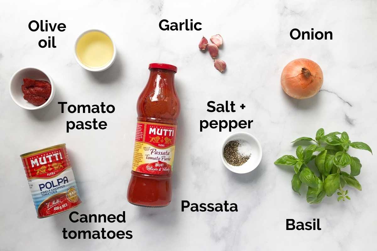 all ingredients for tomato sauce, laid out on a table.