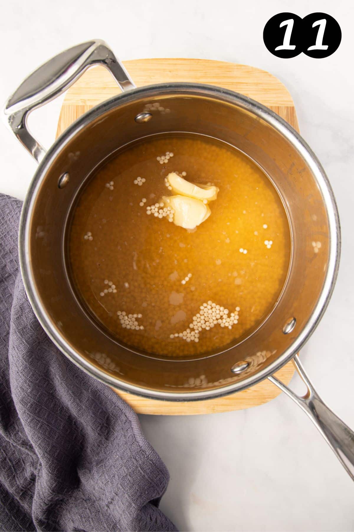 stock and couscous in a pan with butter.