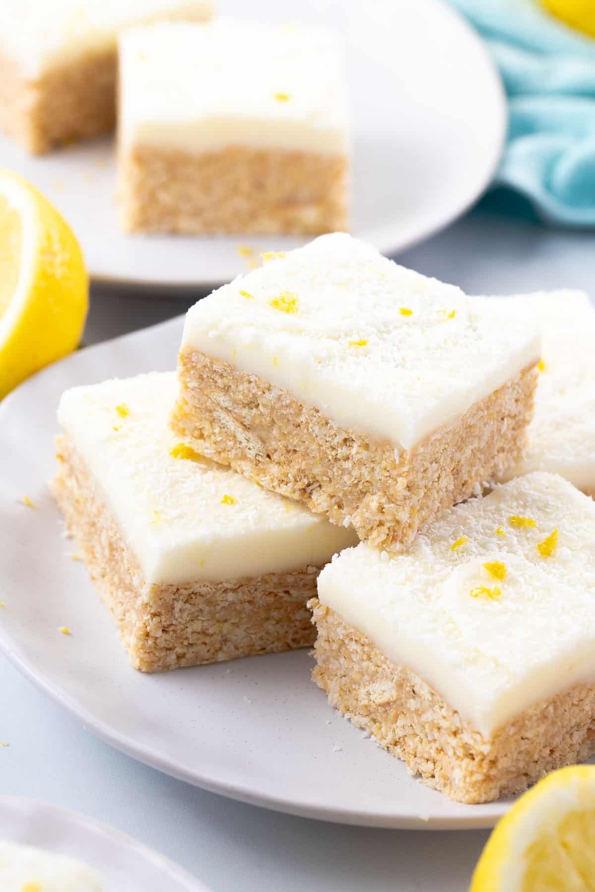 pieces of lemon coconut slice arranged on a plate topped with icing.