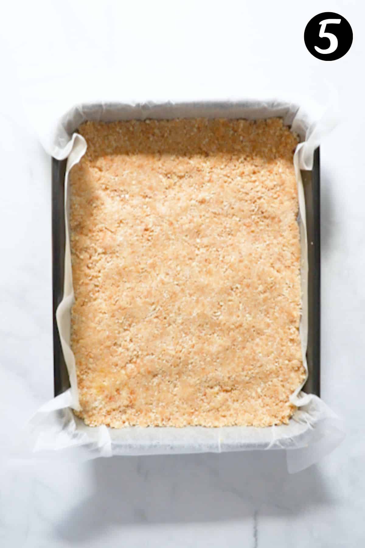 a biscuit base pressed firmly into a baking tin lined with paper.