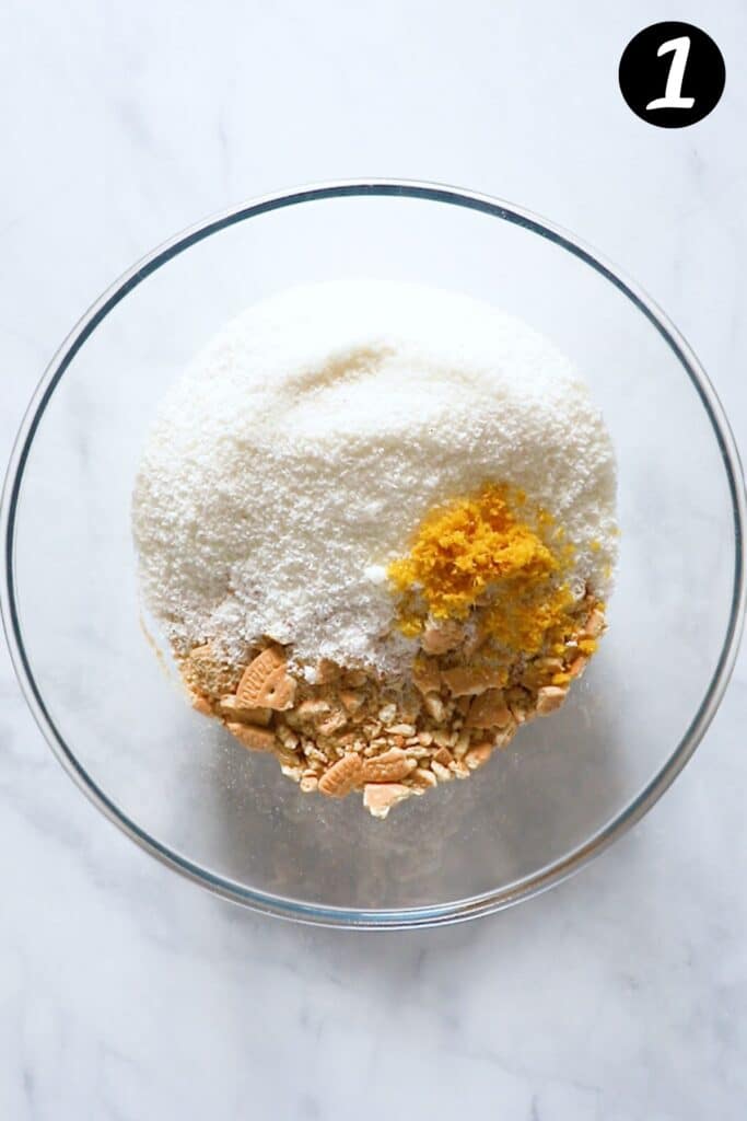 crushed biscuits in a mixing bowl with coconut and lemon zest.
