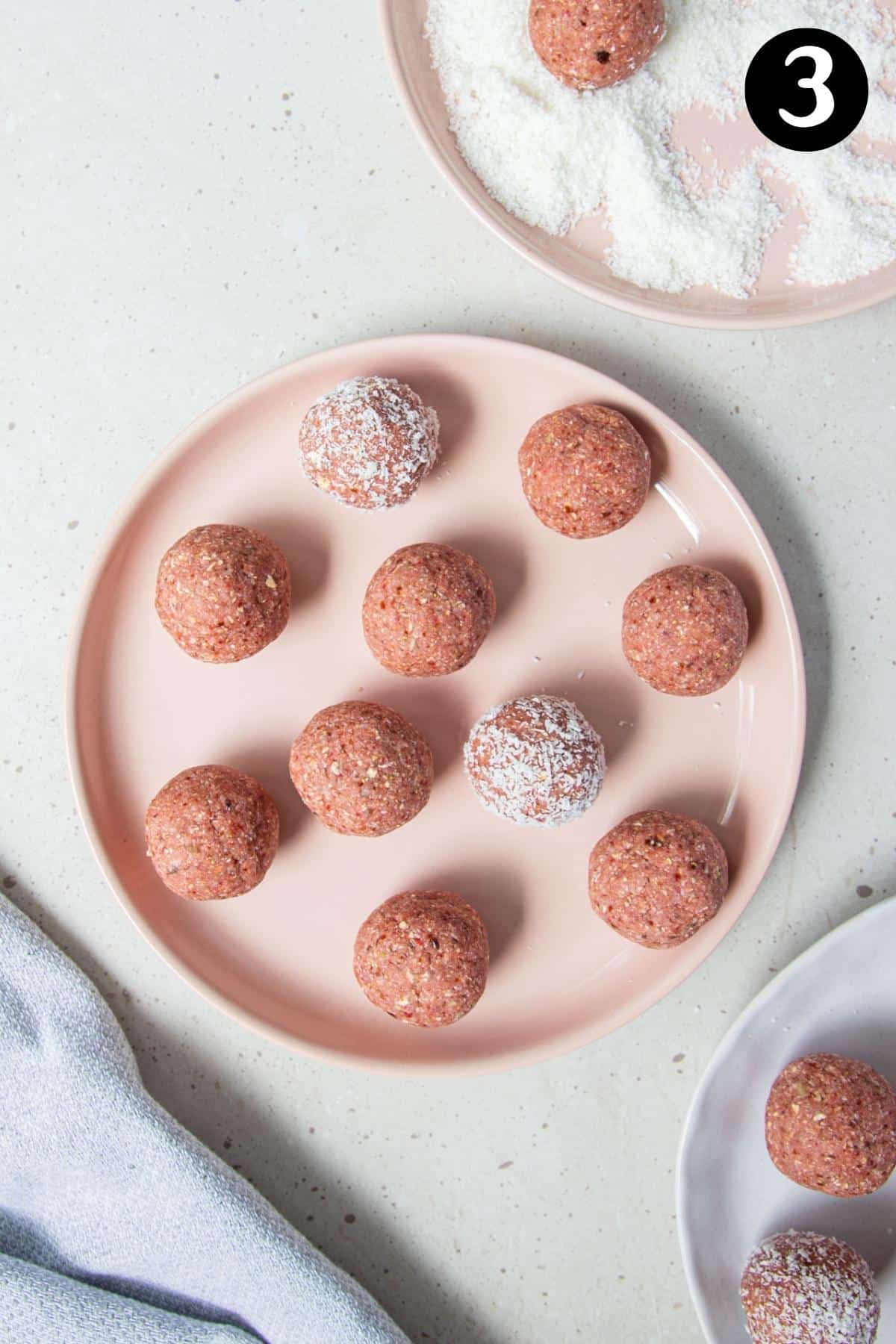 bliss balls on a plate with coconut.