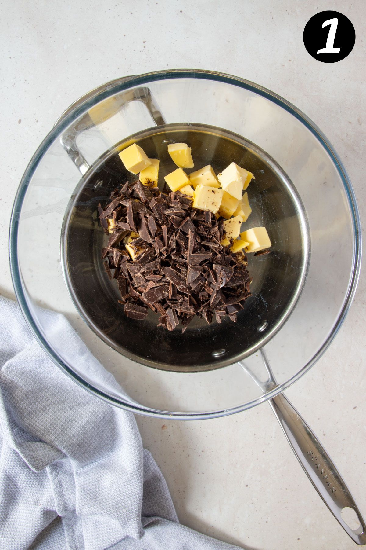 chocolate and butter in a glass bowl over a saucepan.