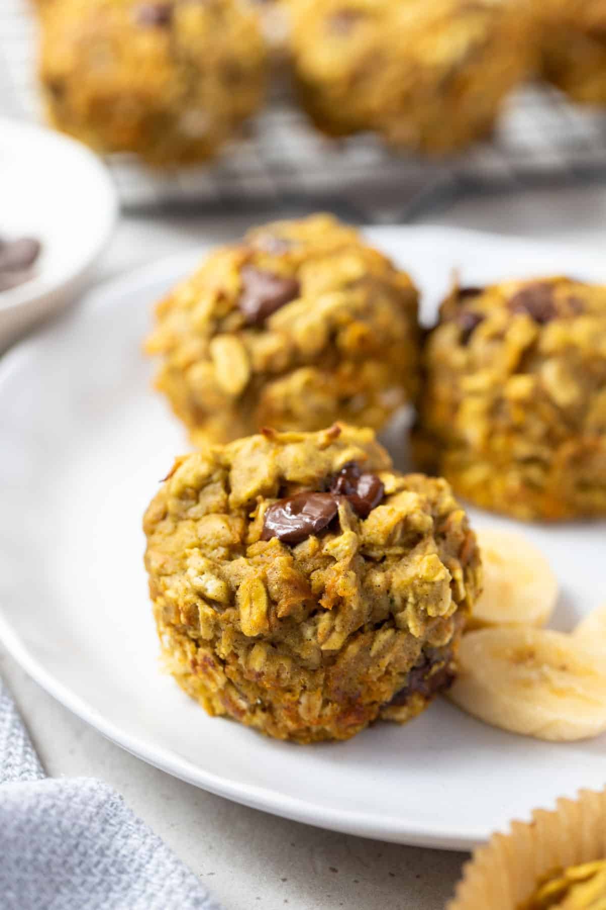 muffins on a white plate with slices of banana