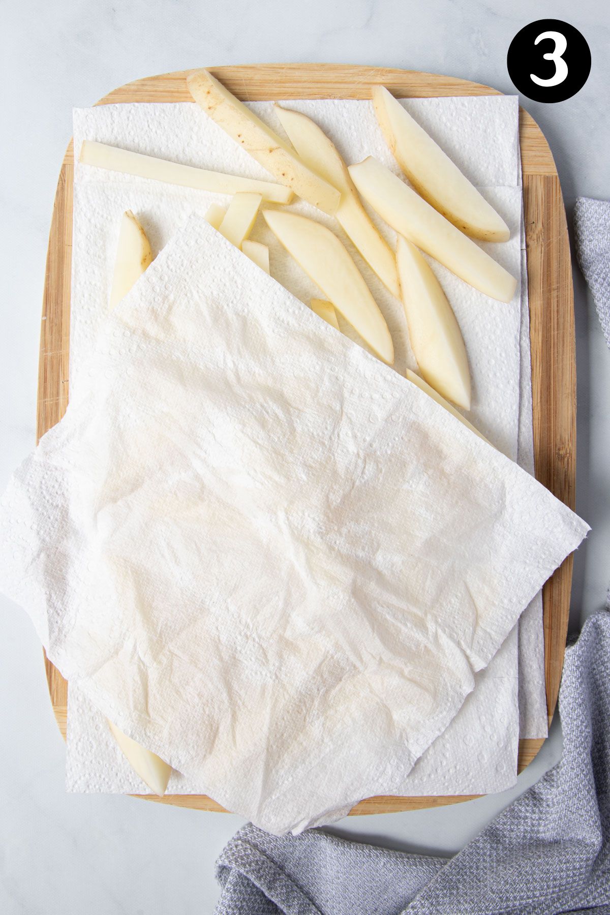 potato chips on a wooden board with paper towel.