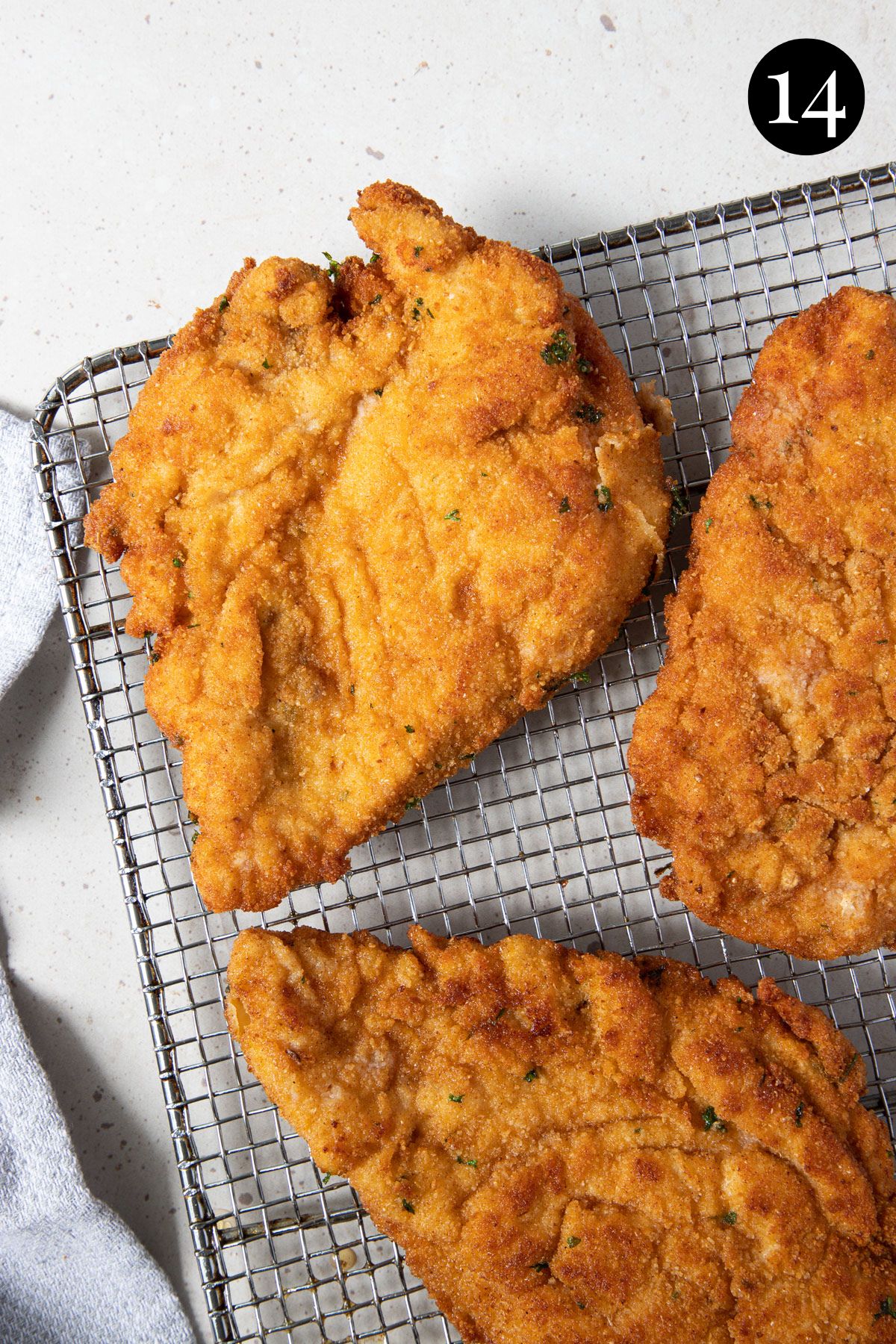 fried chicken schnitzels with golden coating, on a wire rack.