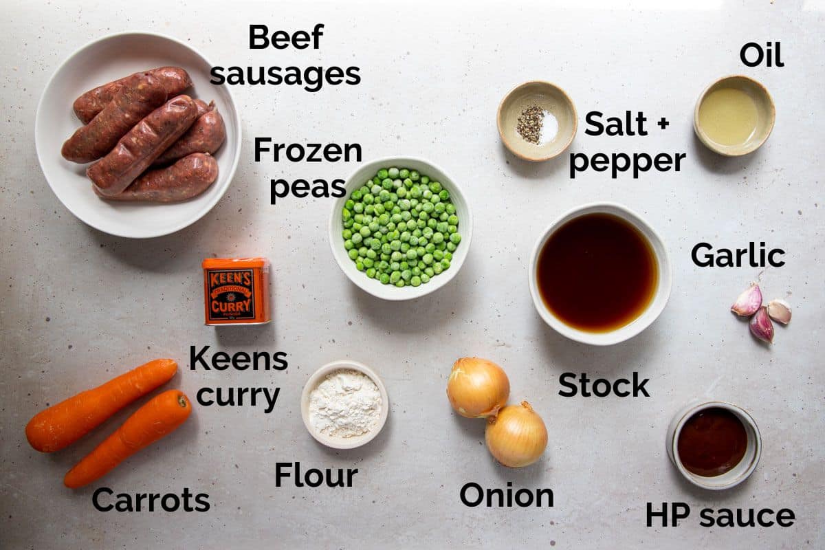 all ingredients for curried sausages, laid out on a table.