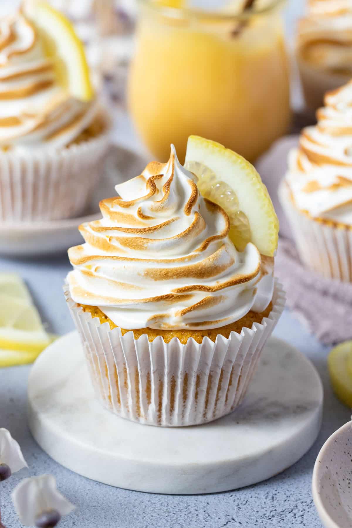 a cupcake on a white dish, topped with toasted meringue.