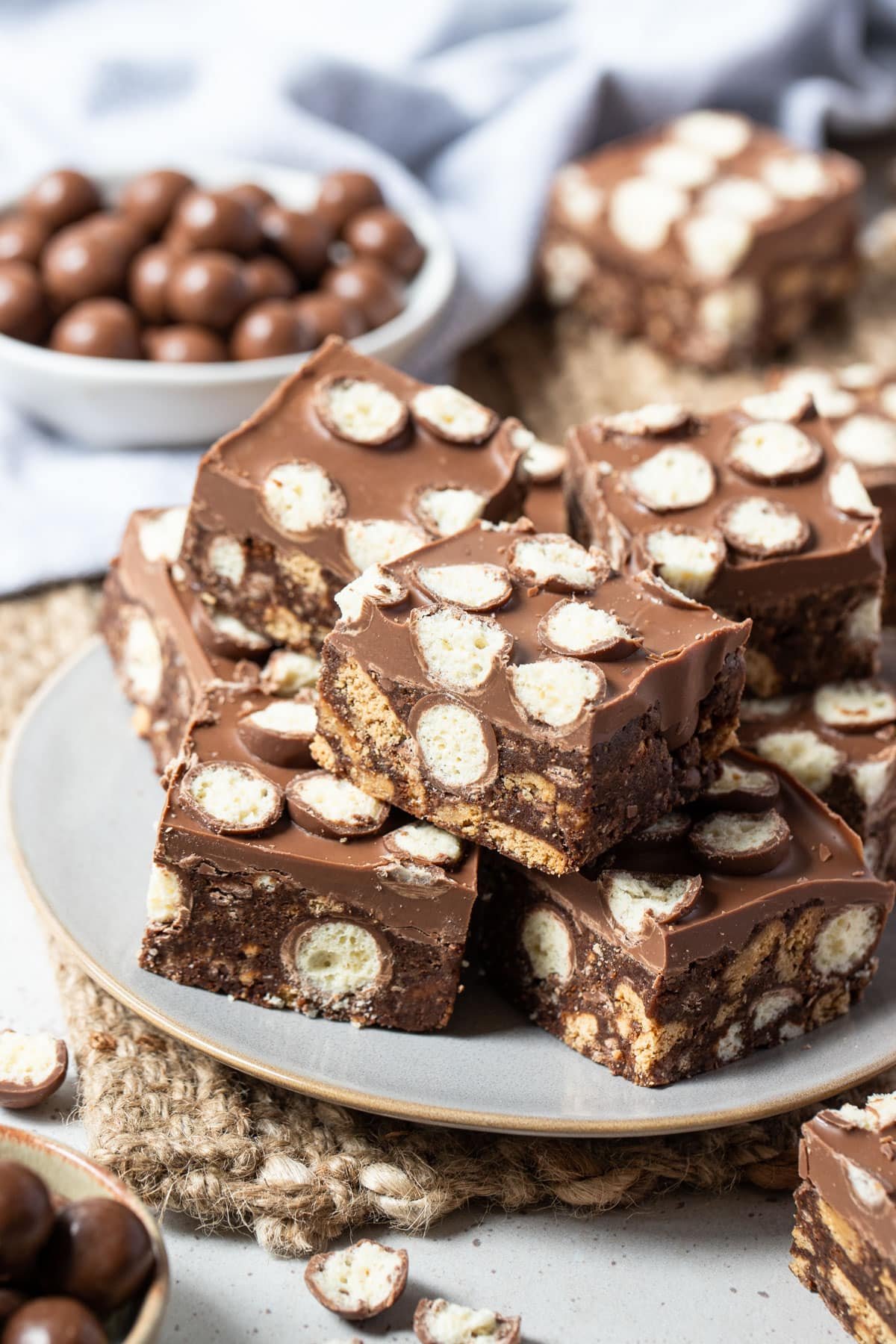 maltesers slice pieces on a plate, topped with chocolate and maltesers.