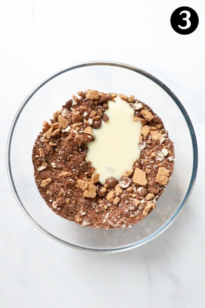 condensed milk and butter with crushed biscuits in a bowl.