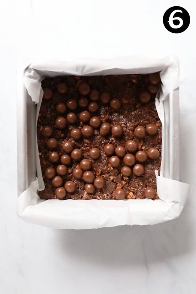 maltesers pressed into base of slice in a tin. 