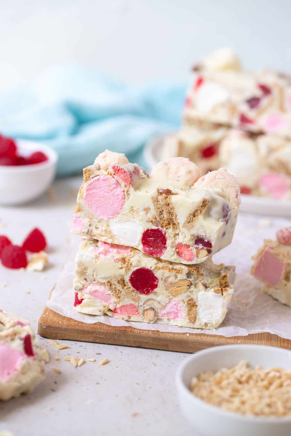 pieces of rocky road coated in white chocolate, on a wooden board.