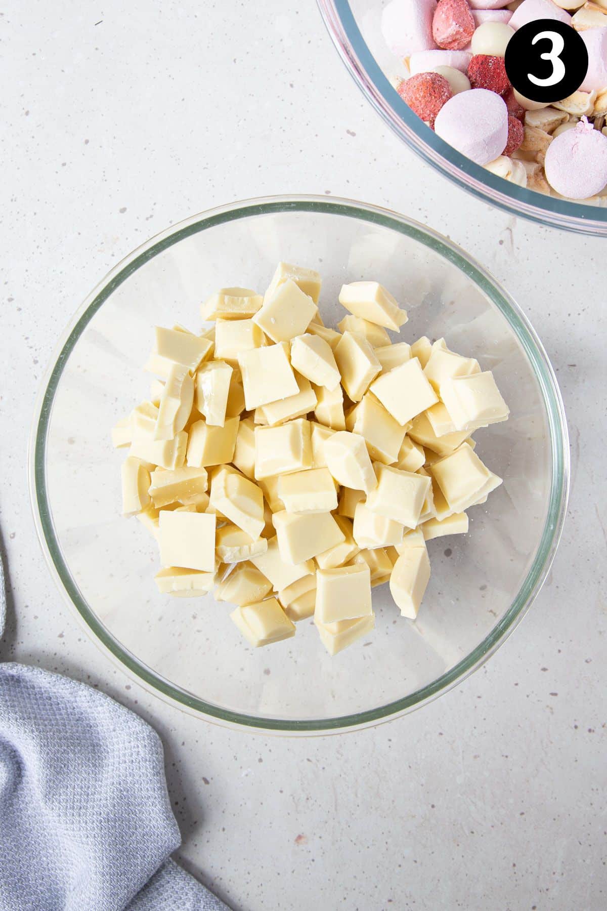 pieces of white chocolate, broken into a glass bowl.