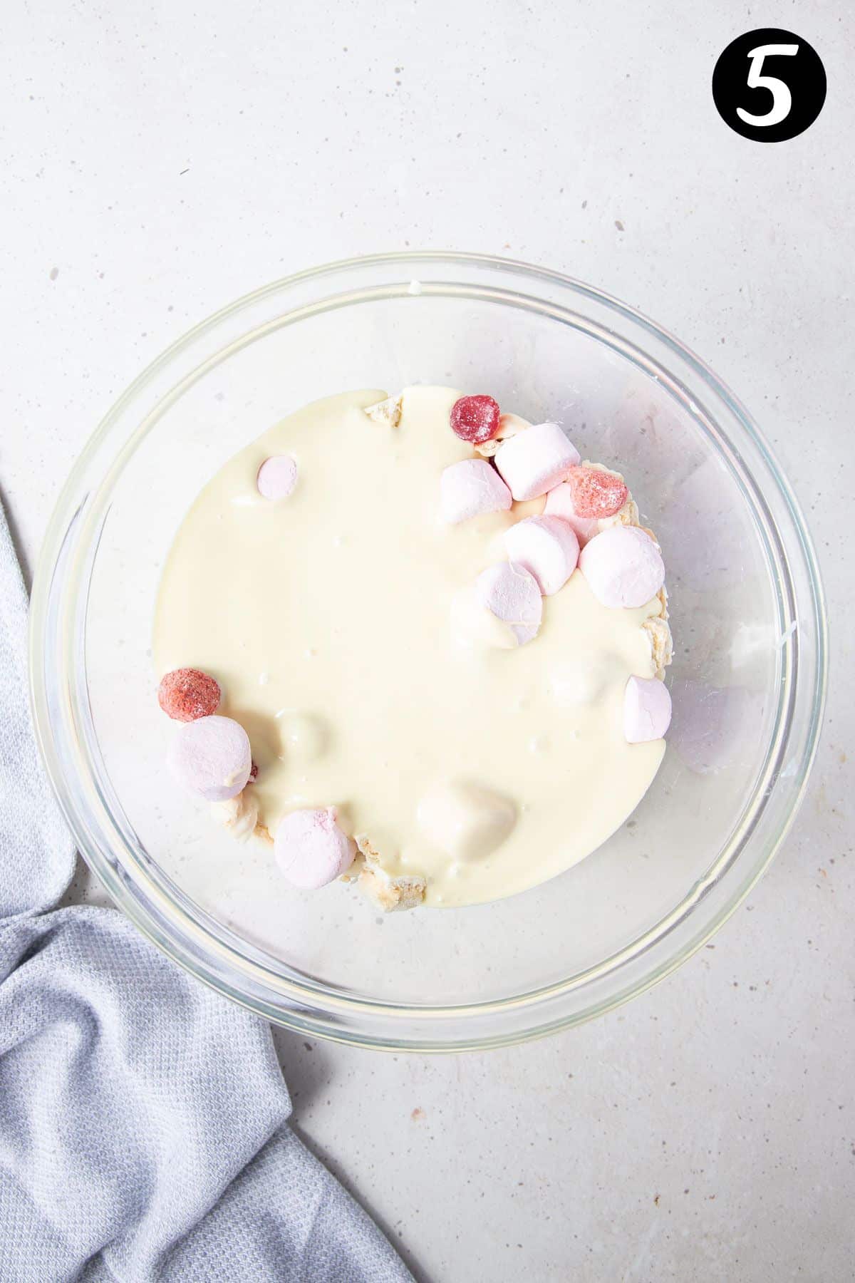 white chocolate poured over filling ingredients in a bowl.