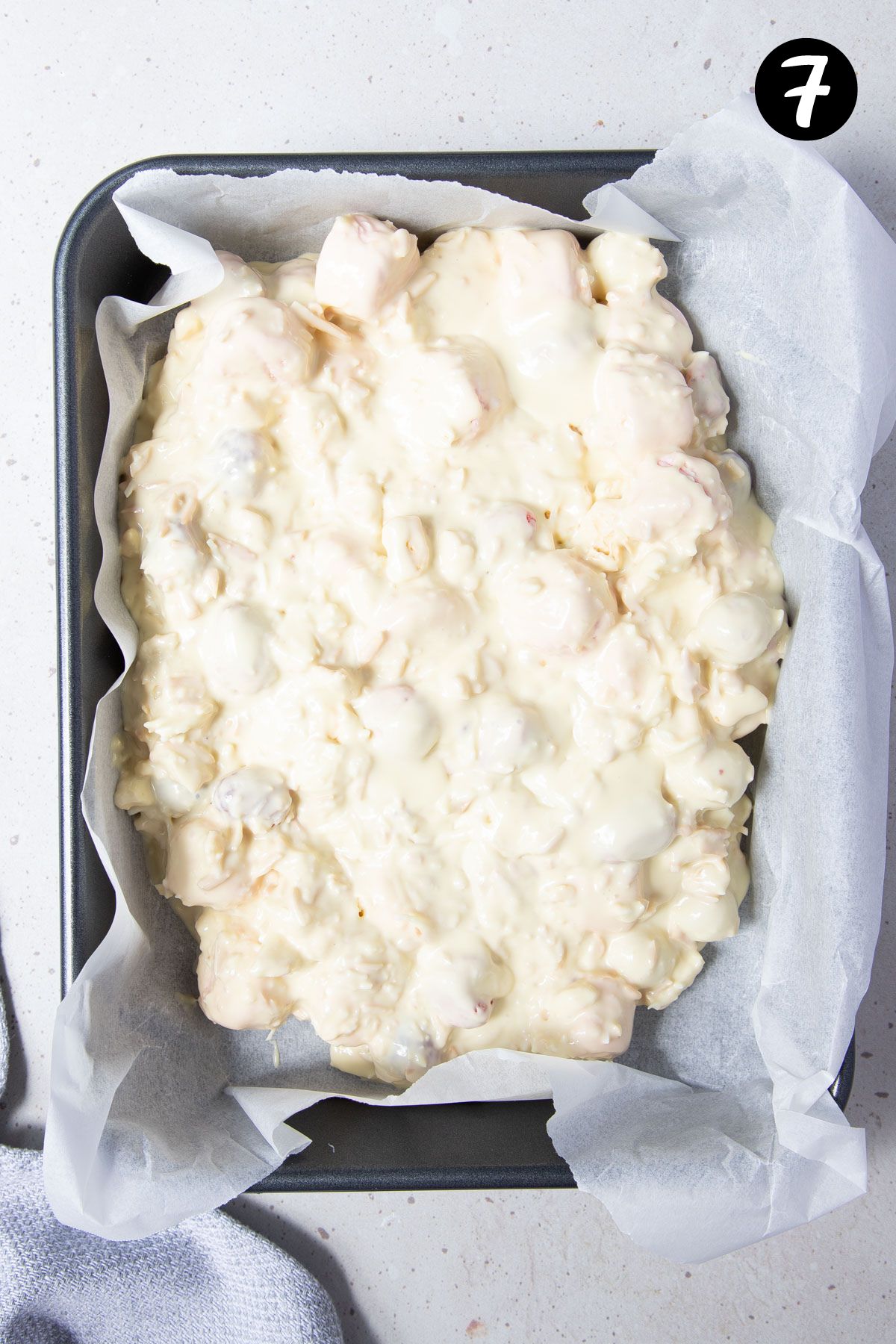 rocky road mixture spread into a tin lined with baking paper.