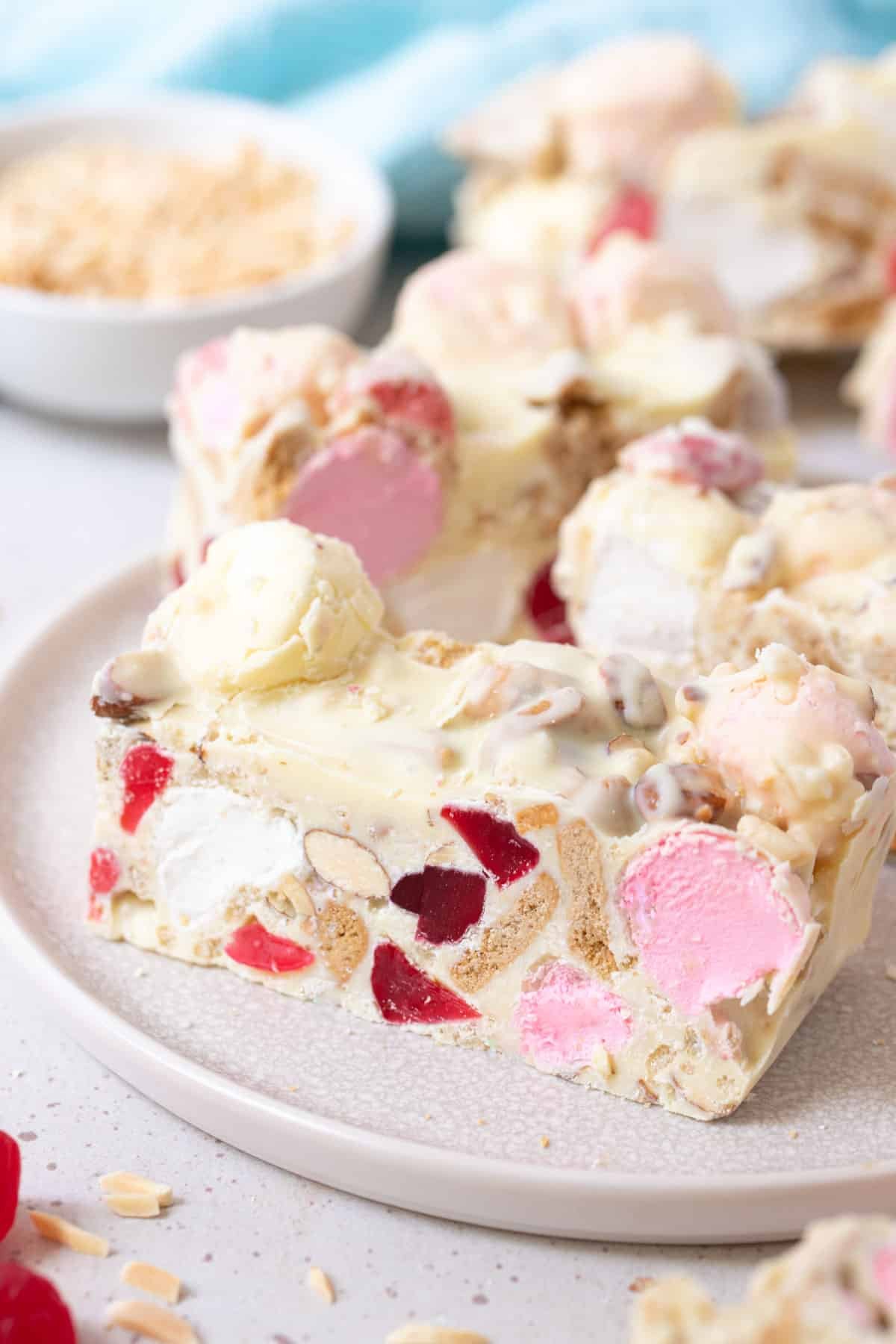 a plate of white chocolate rocky road cut into pieces, showing the marshmallow and lollies centre..