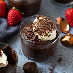 a jar of chocolate avocado mousse topped with cream and chocolate.