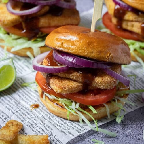 halloumi burgers on a table, with salad and chips.