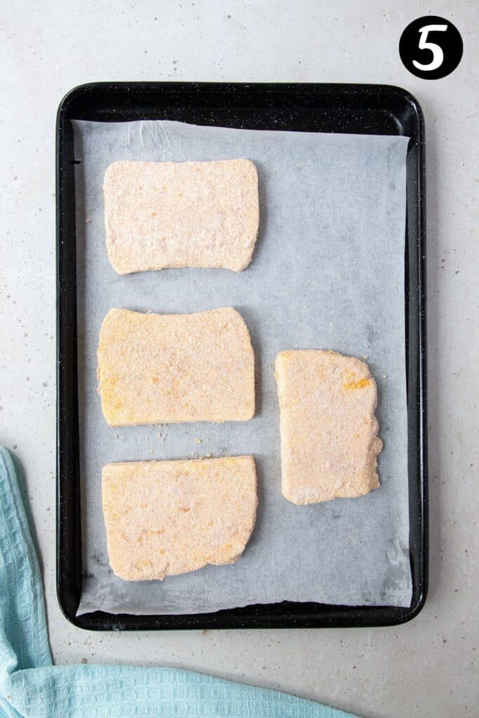 blocks of crumbed halloumi cheese on a tray lined with paper.