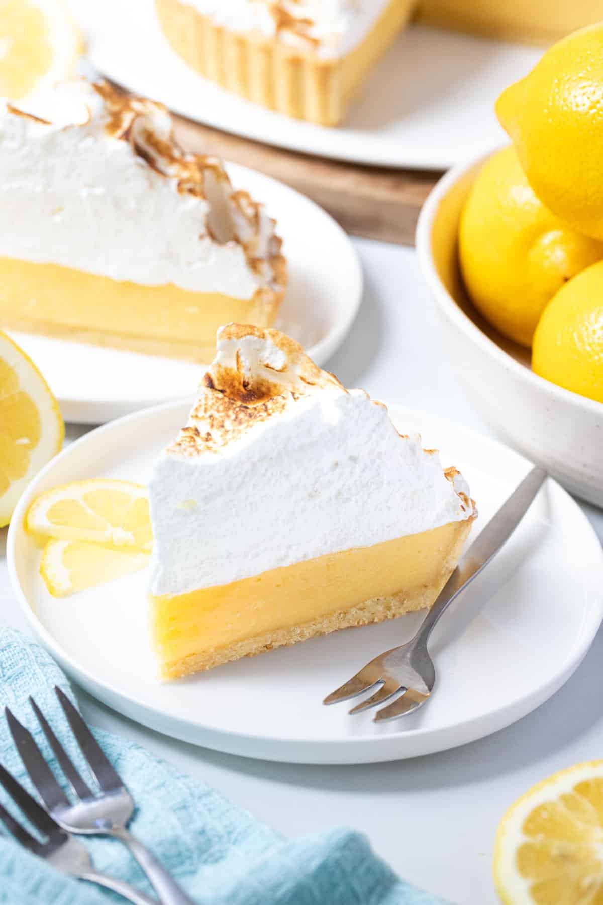 a slice of lemon pie on a plate, topped with toasted meringue.