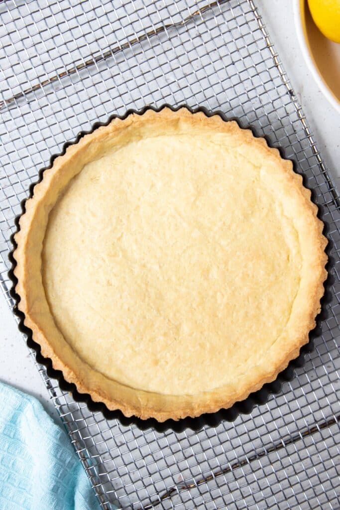 baked pie crust in a tin, on a wire rack.