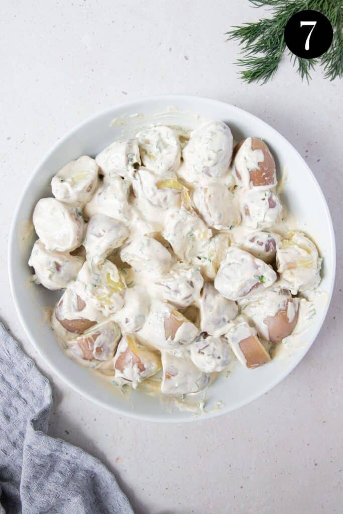 potatoes in a bowl covered in salad dressing.