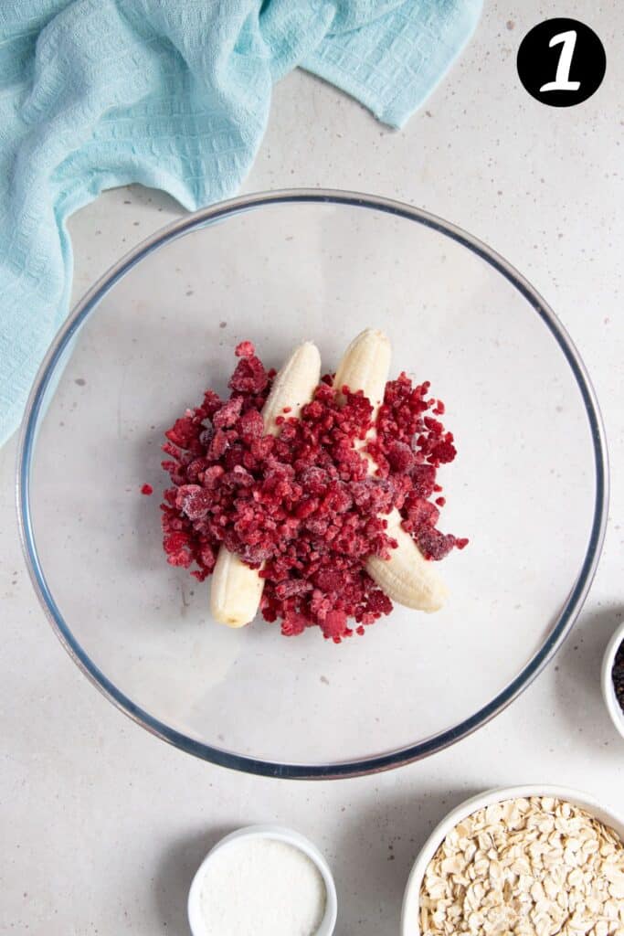 banana and frozen raspberries together in a mixing bowl.