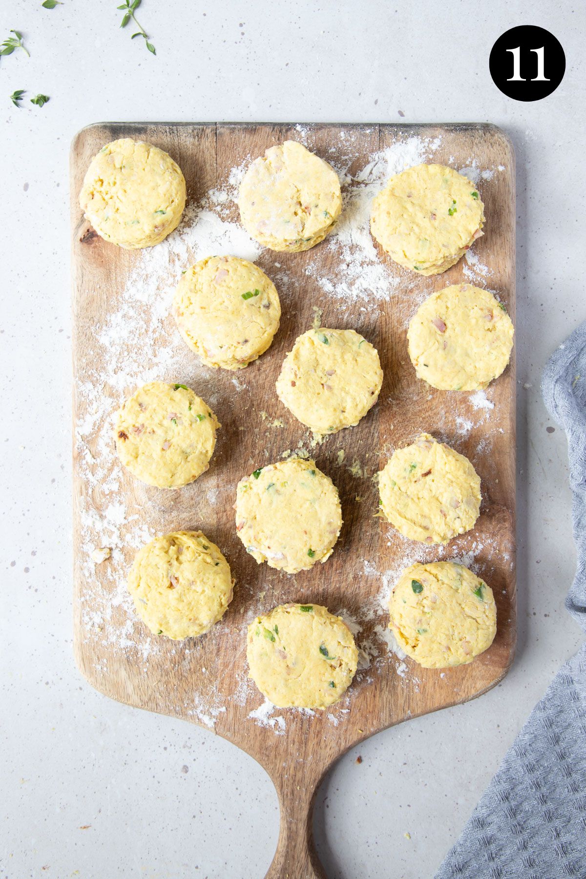 12 pieces of scone dough, on a floured board.