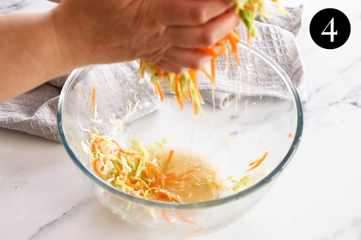 hands squeezing liquid from cabbage and carrot mixture.
