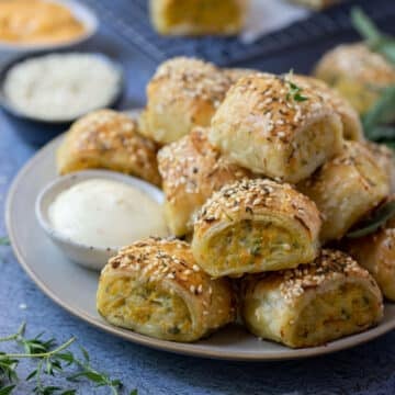 chicken sausage rolls on a plate with dipping sauce.