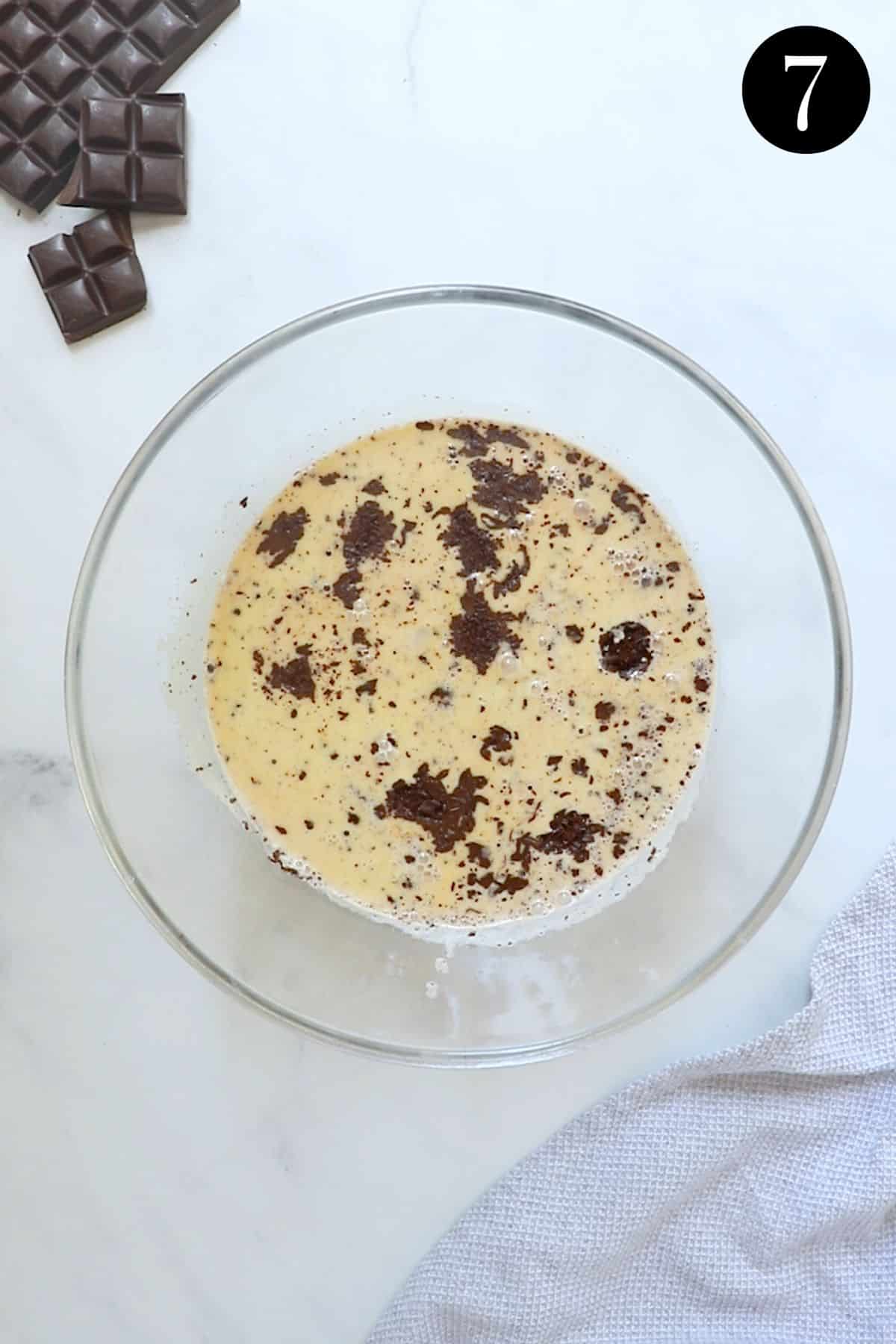 hot cream mixture poured over chocolate pieces in a bowl.