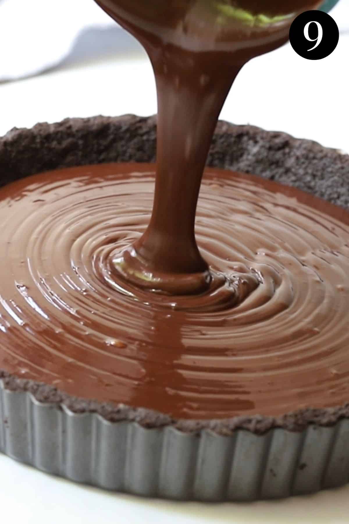 chocolate ganache being poured into a biscuit base.