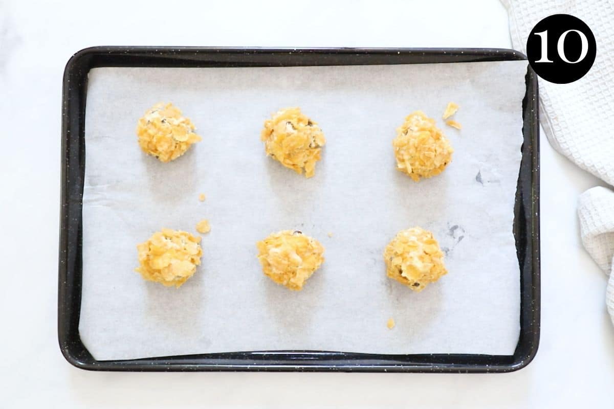 balls of cookie dough on a baking tray lined with paper.