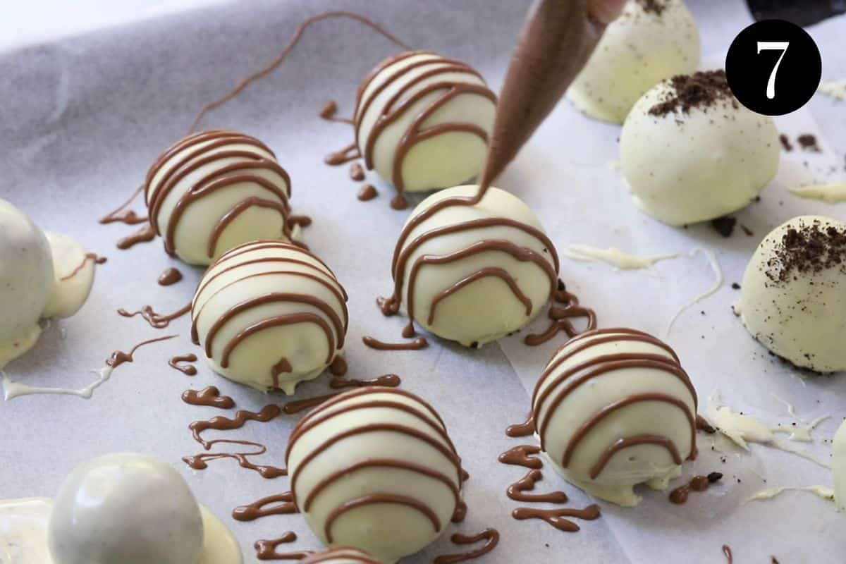 a piping bag drizzling melted chocolate over Oreo balls on a tray.