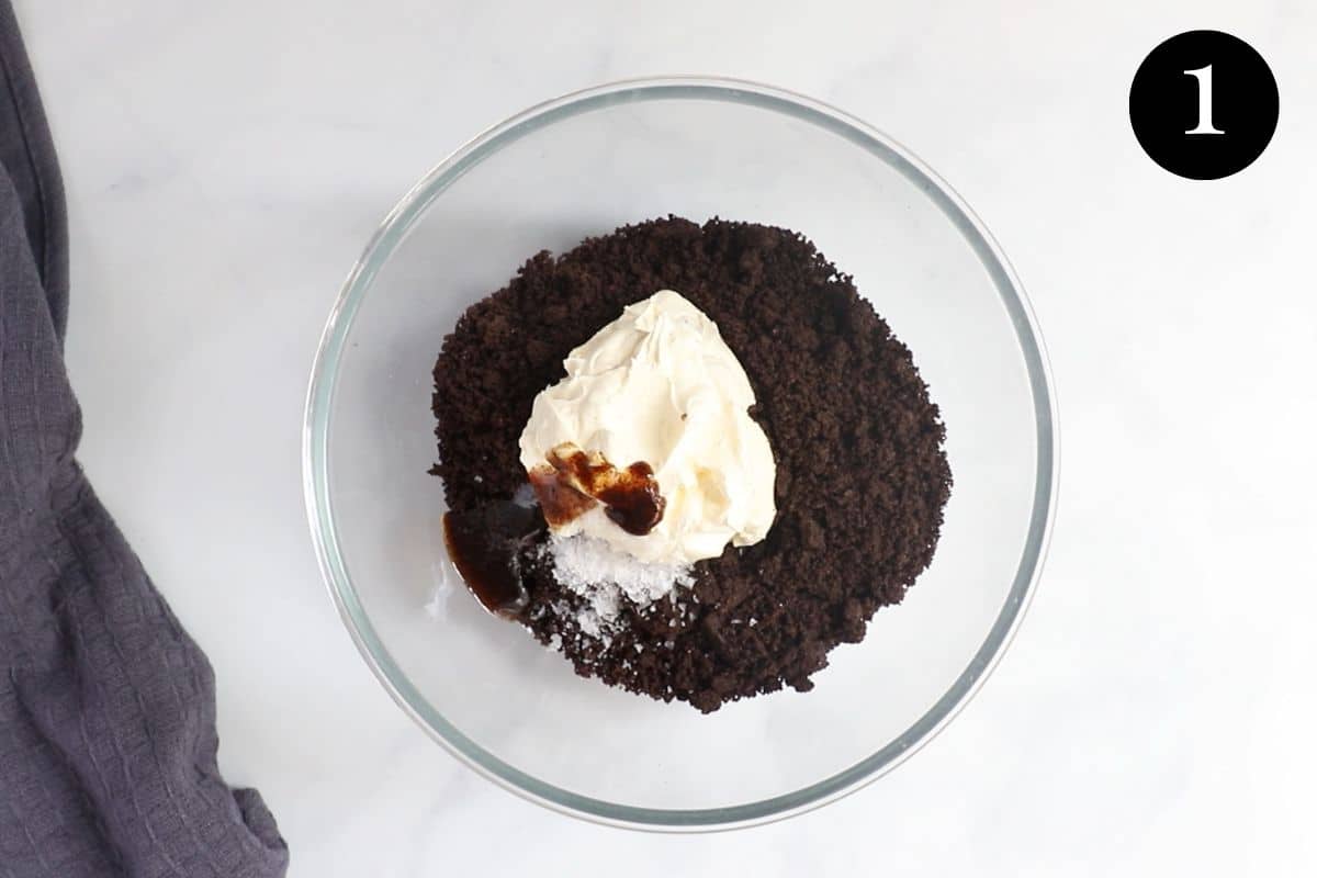 crushed oreos and cream cheese in a mixing bowl.