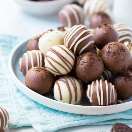 oreo balls coated in chocolate piled on a plate.