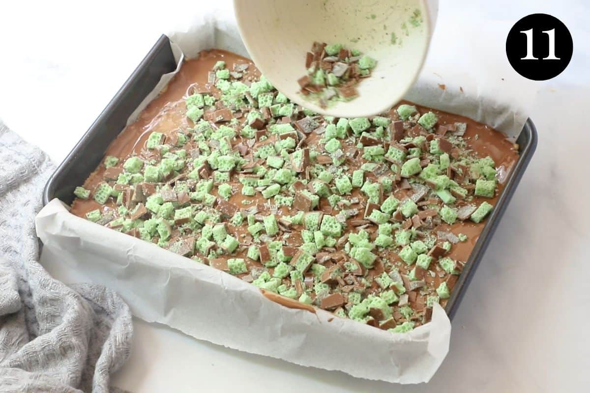 pieces of peppermint chocolate being poured over finished slice in a tin.