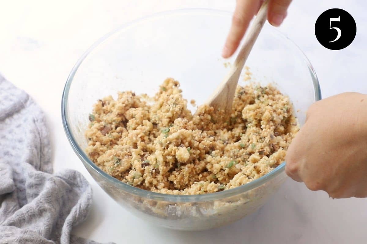hands stirring biscuit base mixture in a bowl.