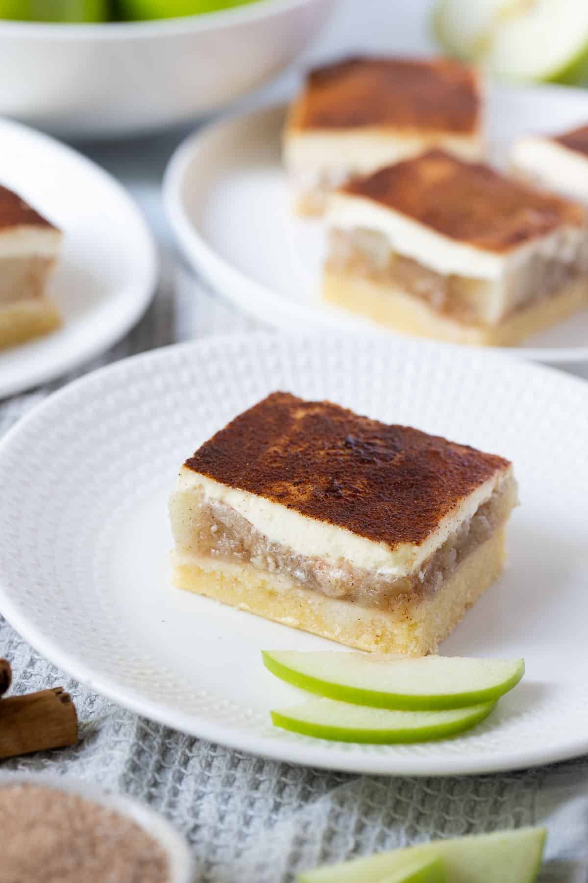 apple sour cream slice on a white plate with slices of green apple.