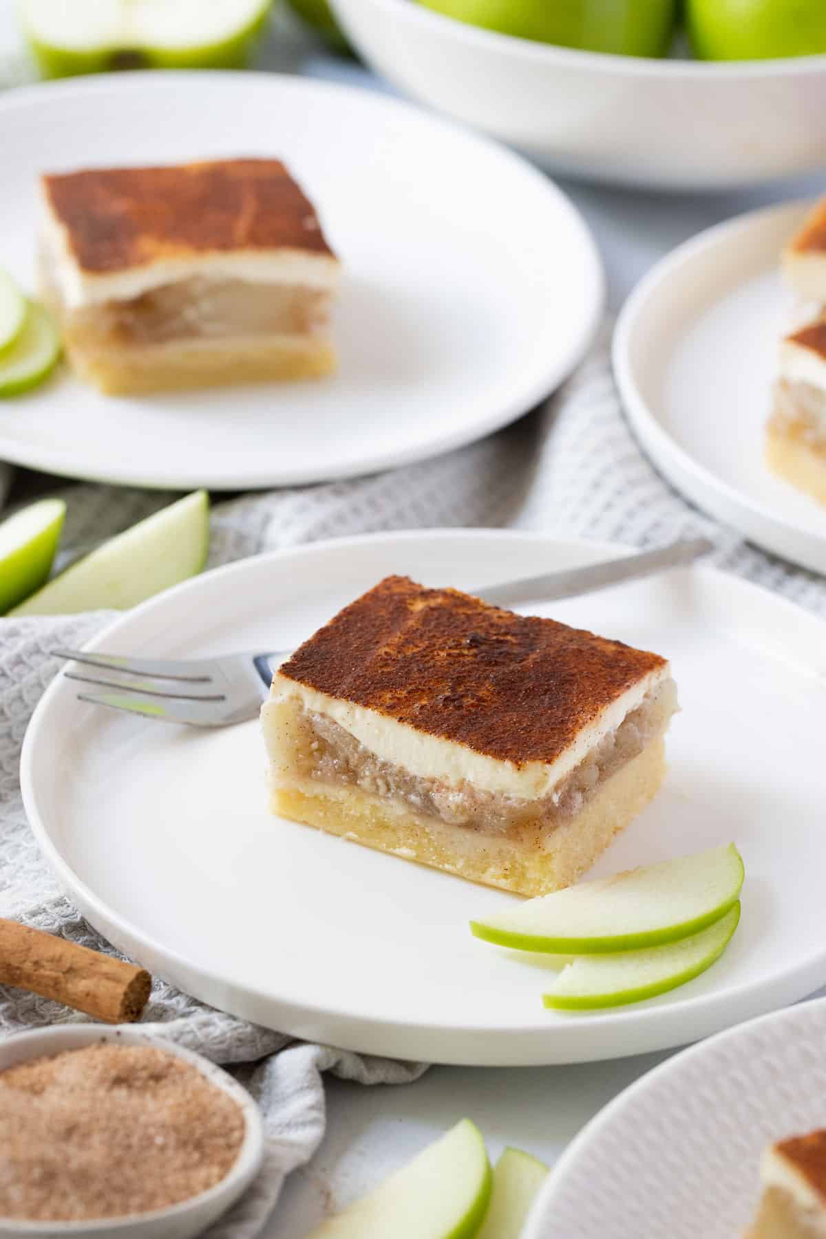 apple slice with sour cream topping on a white plate.