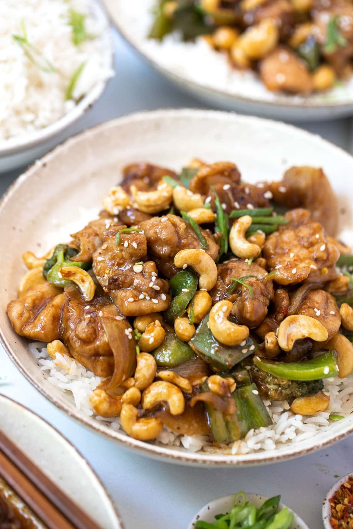 a bowl of chicken and cashew stir fry with vegetables and rice.