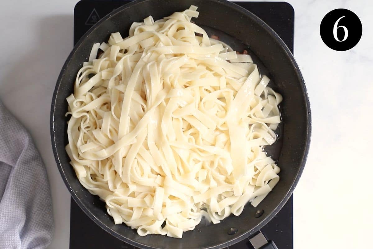 a pan with cooked pasta and bacon.