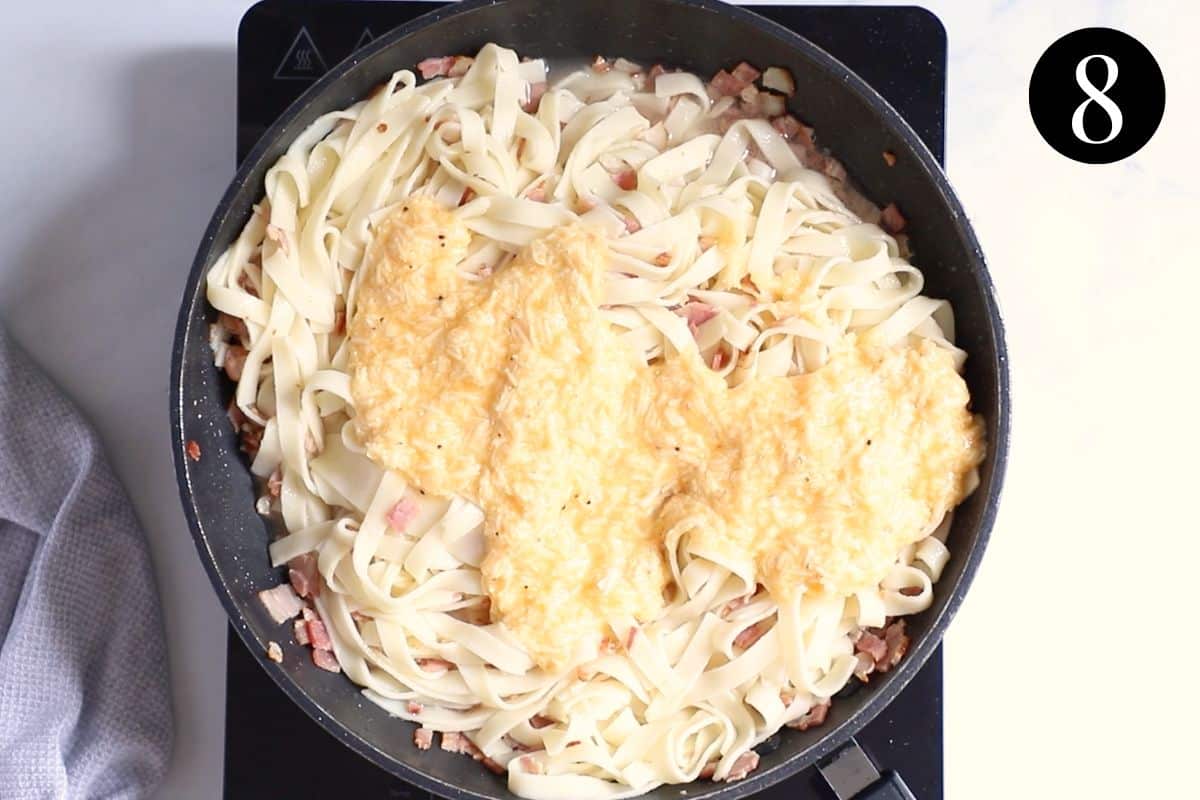 egg mixture being added to pasta in a pan.
