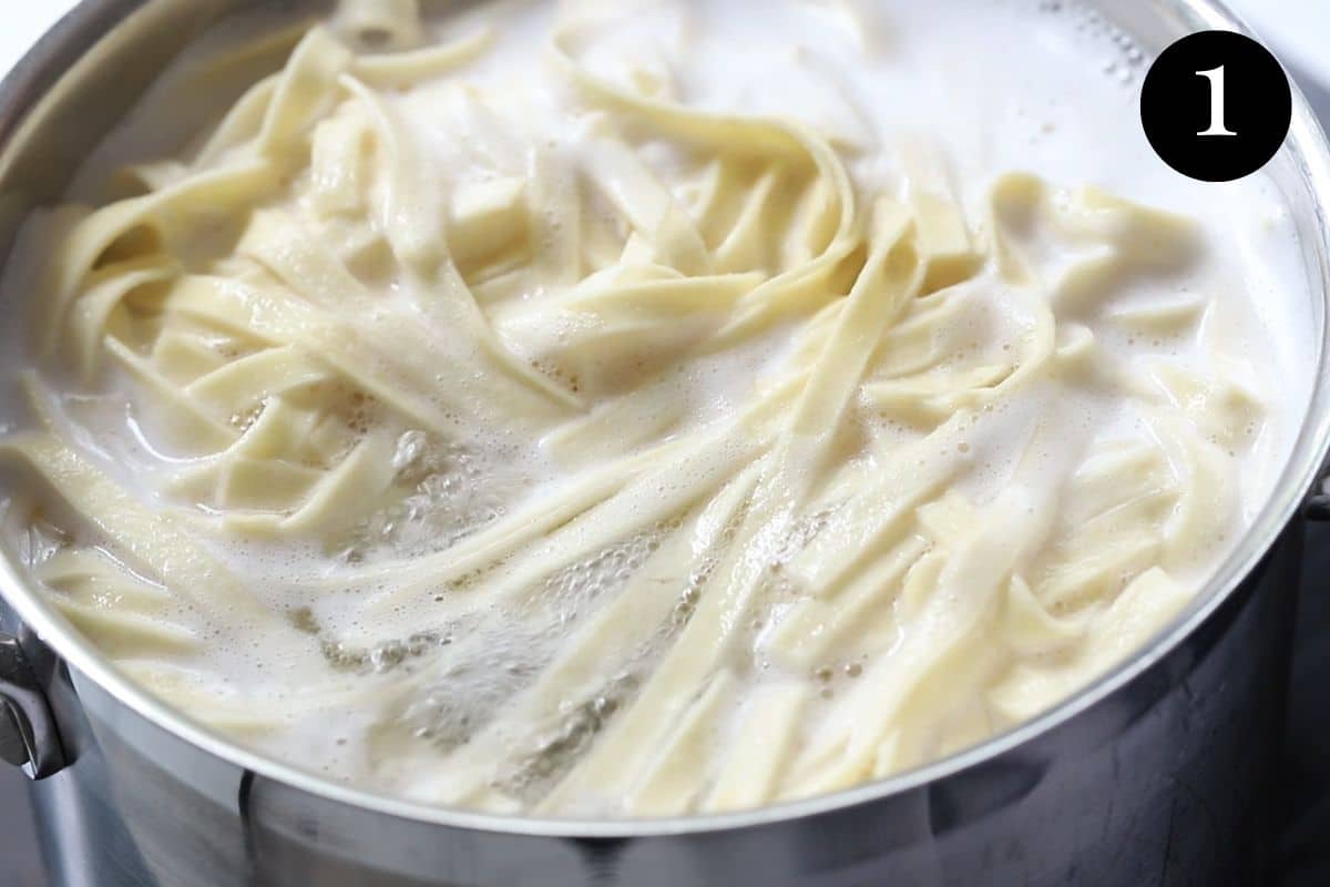 fettucine cooking in a pot of boiling water.