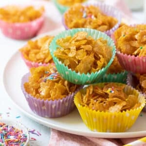 honey joys in colourful paper cases, on a white plate.