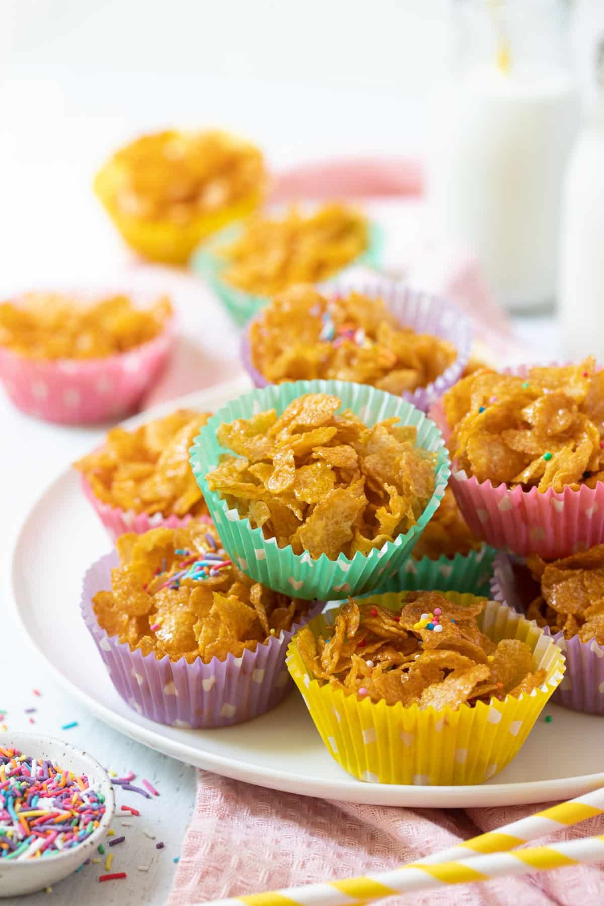 honey joys in colourful paper cases, arranged on a white plate.