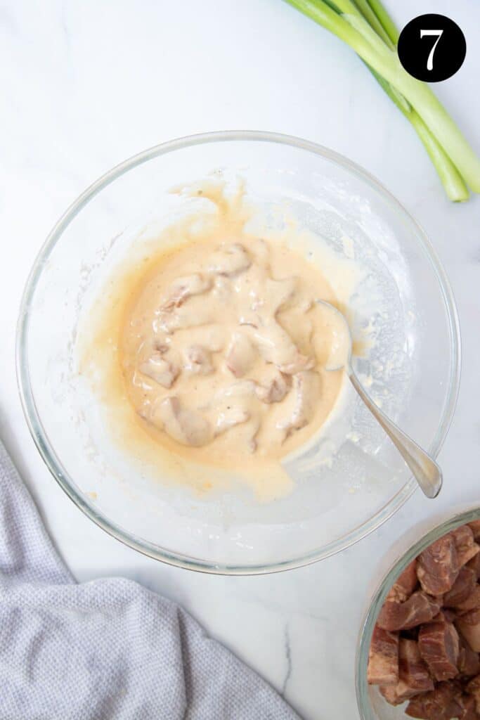 pieces of pork in a bowl, coated in batter.