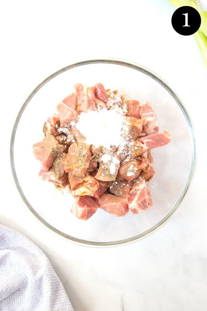 pieces of pork in a bowl with marinade ingredients.