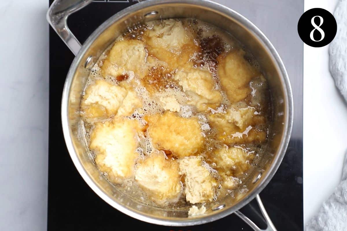 dumplings in golden syrup in a pan.
