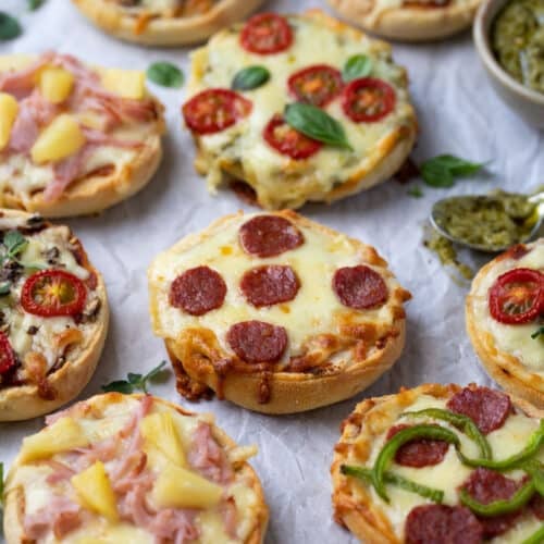 pizza muffins on a table with pizza sauce.